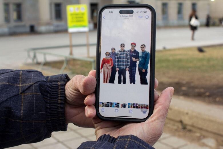 A phone is shown with five people seen in a photo.