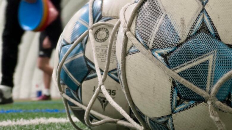 Soccer balls sit on the turf at the Calgary West Soccer Centre.