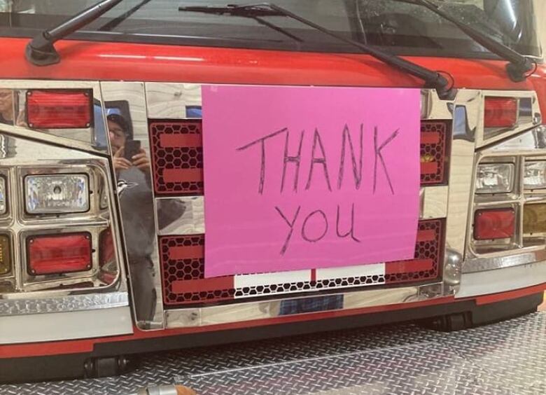 a pink sign 'thank you sign' on the front of a fire engine 