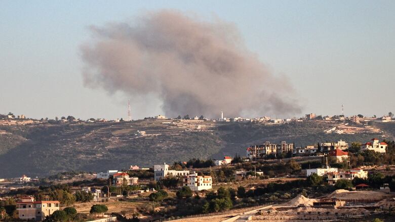 Smoke billows above a town.