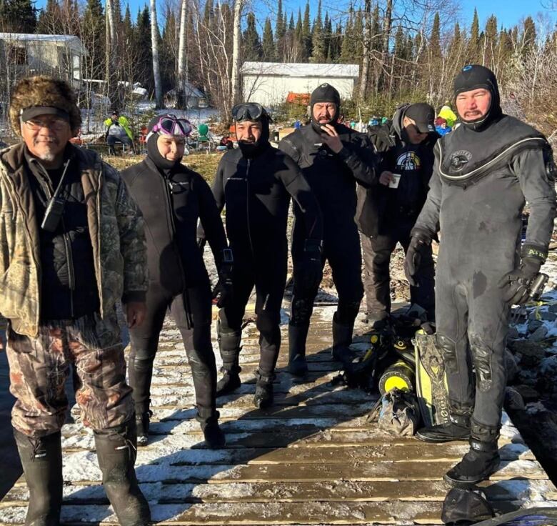 A group of divers standing on a dock. 