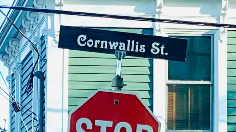 A green house with a black street sign that says Cornwallis Street.