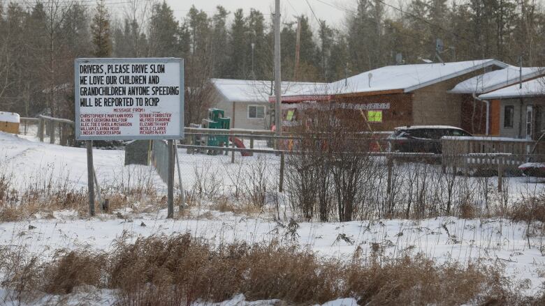 A sign next to some homes in Norway House tells people to drive slowly since the community loves its children.