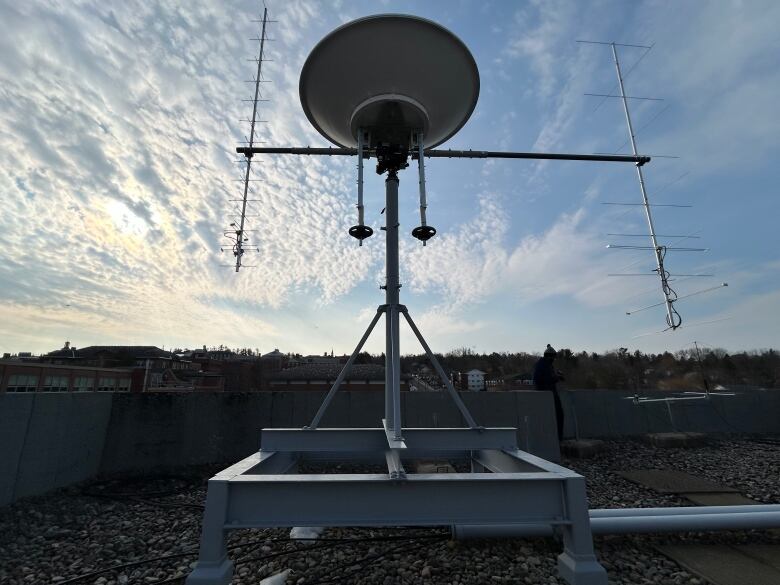 A tall metal structure with a large dish and several small antennas.