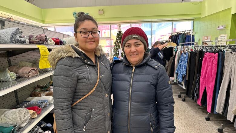 Two women stand in aisle