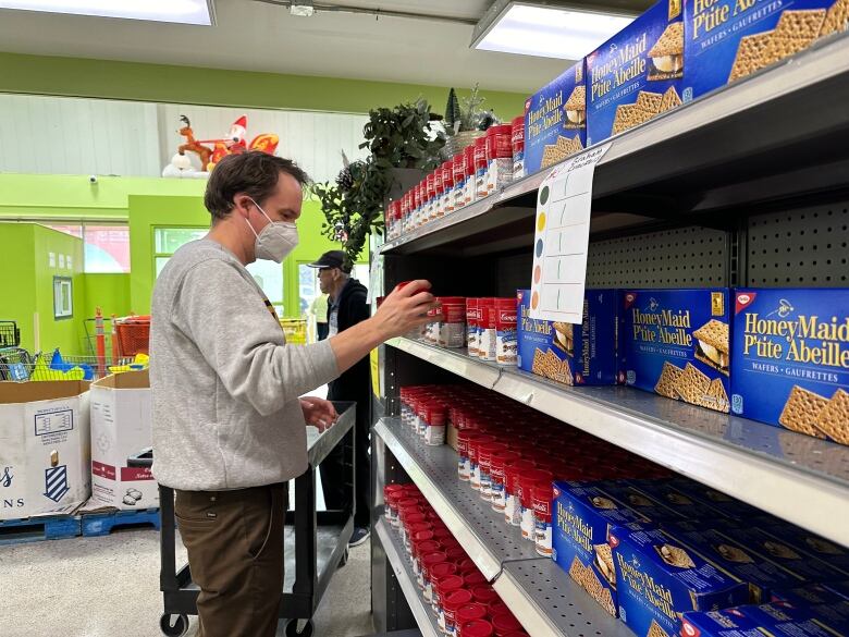 Man stocks soup on shelves