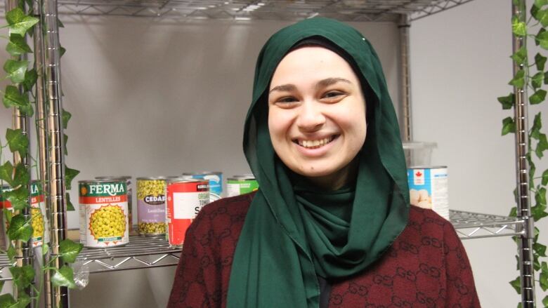 A woman in front of a shelf of canned food