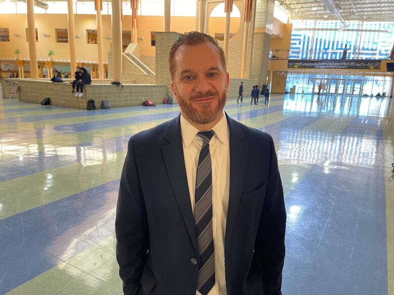 A man in a suit smiles for the camera