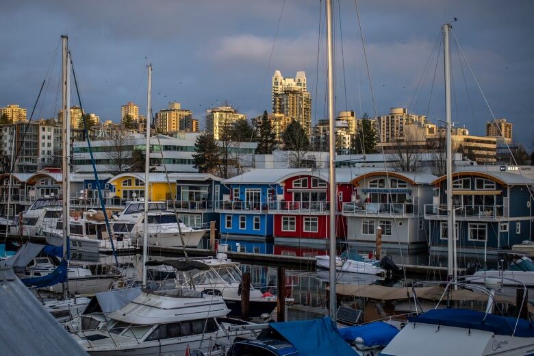 Several boat sheds and float homes lined up on the water.