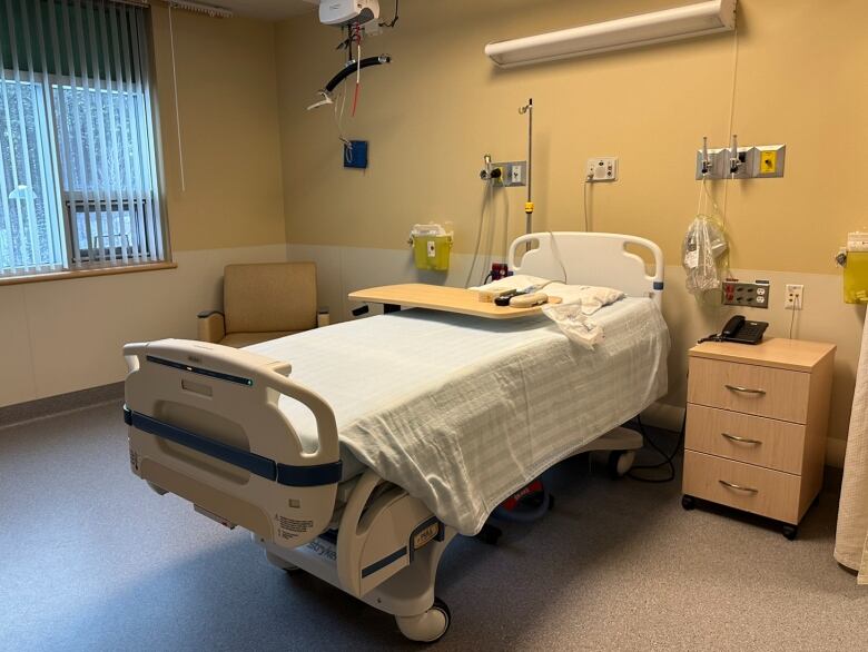 A bed in an empty hospital room.