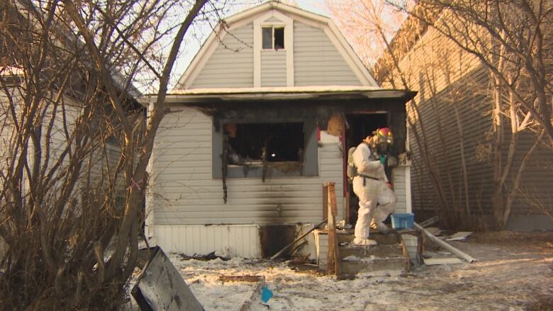 A home has visible damage and charring from fire, but there is no ongoing fire