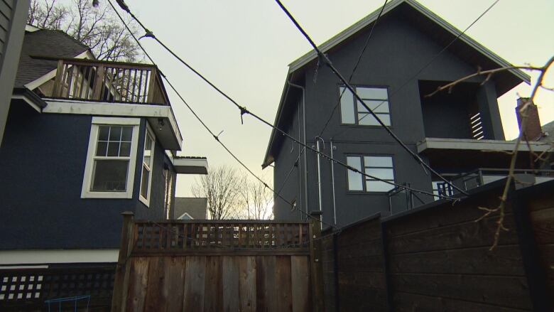 An image of a backyard shows several strings with wires and missing bulbs hanging. 