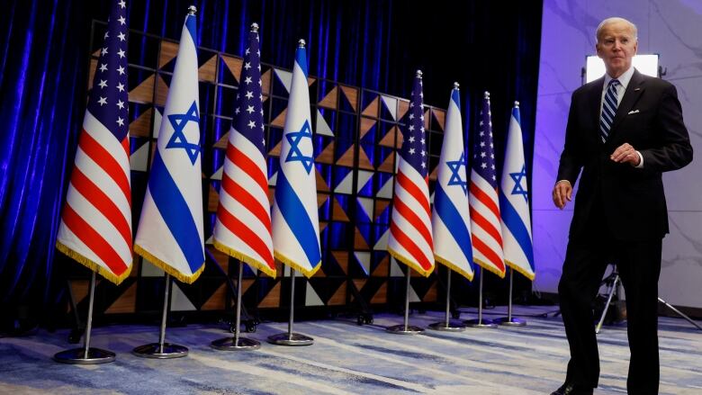 Biden surrounded by U.S. and Israeli flags