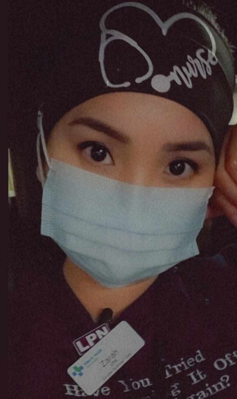 A nurse wearing a mask is pictured