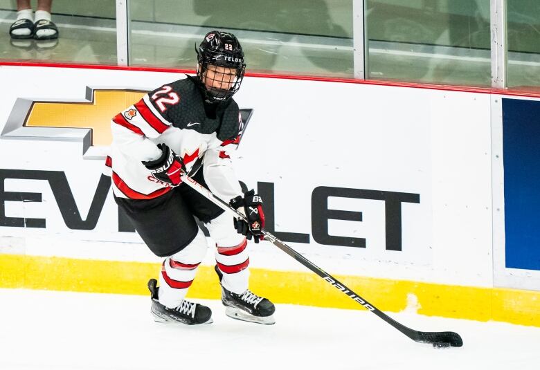 A hokey player in a Team Canada uniform on the ice.