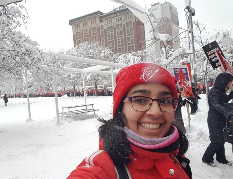 Young woman dressed in red smiles at camera.