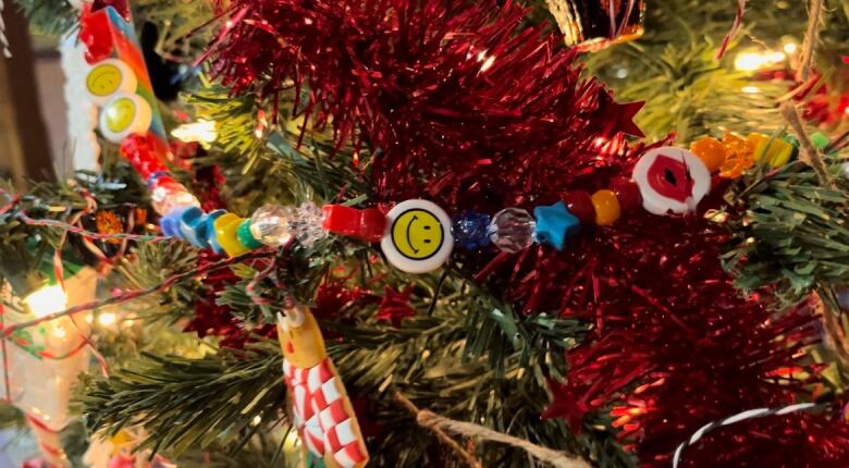 A string of beads is draped over a Christmas tree. 