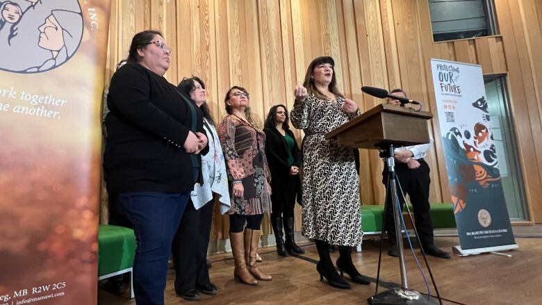 A group of women stand behind a podium.