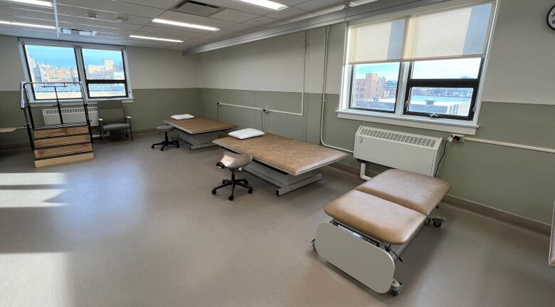 Empty physiotherapy beds are shown in a hospital room.