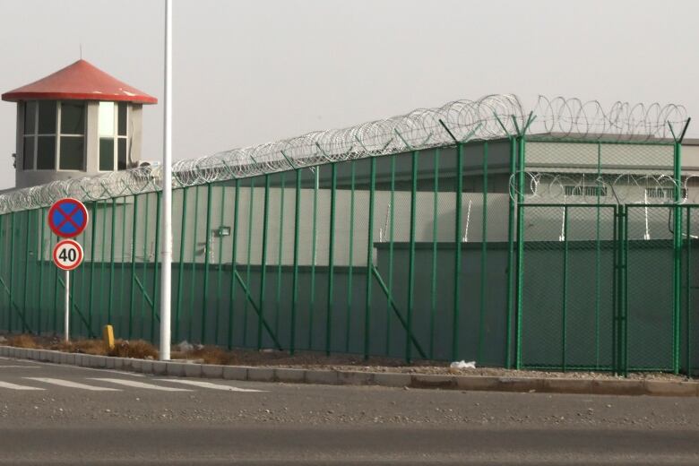 In this Monday, Dec. 3, 2018, file photo, a guard tower and barbed wire fence surround a detention facility in the Kunshan Industrial Park in Artux in western China's Xinjiang region.