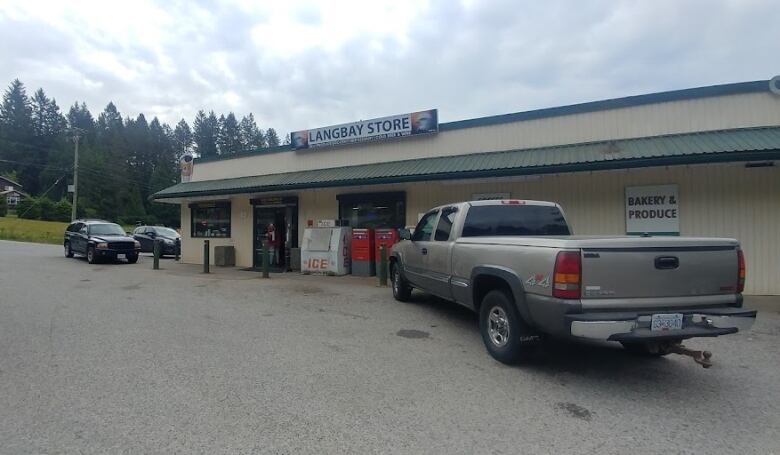 Cars are parked outside a corner store with a a sign that reads 