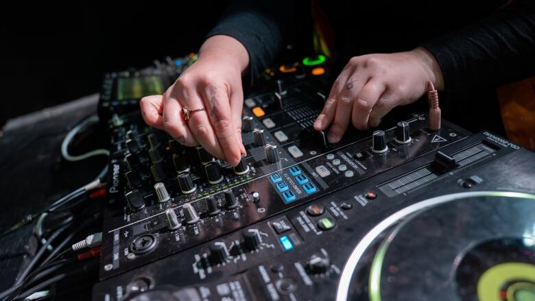 A DJ plays with a DJ controller on stage.