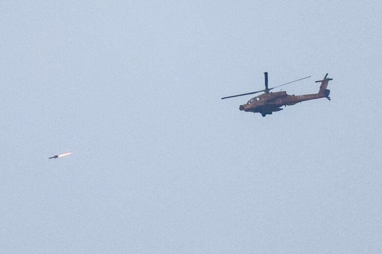 A helicopter fires a missile while flying.