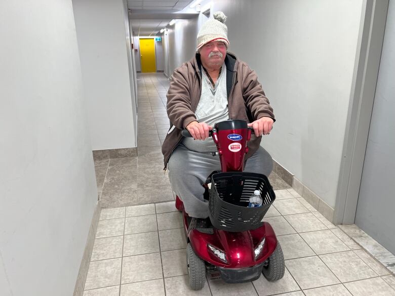 Man on scooter in hallway.