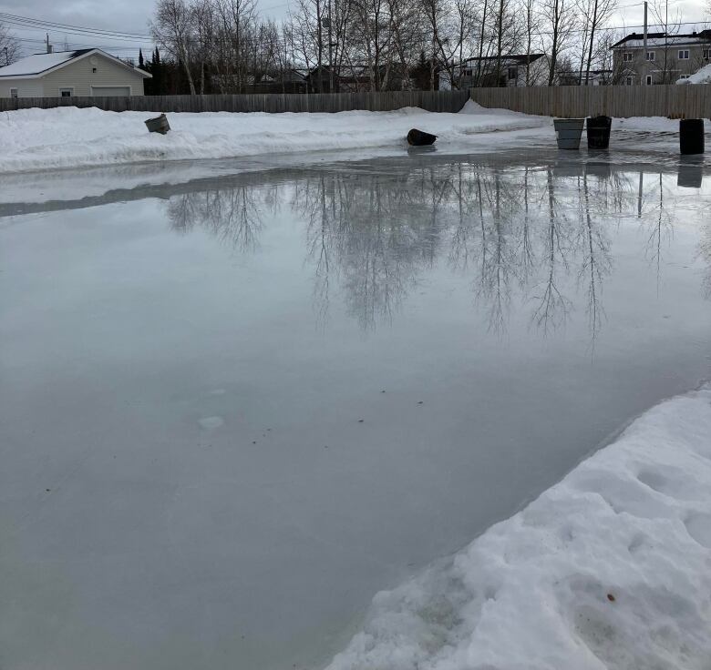 A pool of water is surrounded by small amounts of snow.