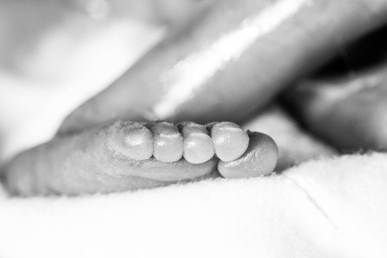 A baby's foot is shown in black and white. 