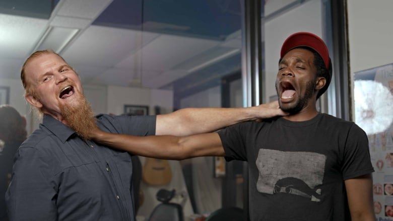 Aaron Low and Anthony Morgan stand and pretend to strangle each other after a voice adjustment session