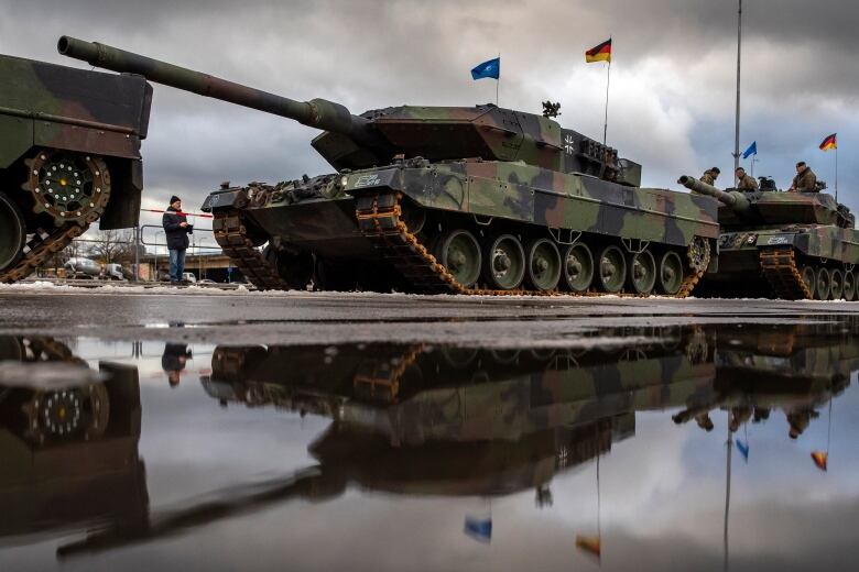 Tanks parade down a city street.