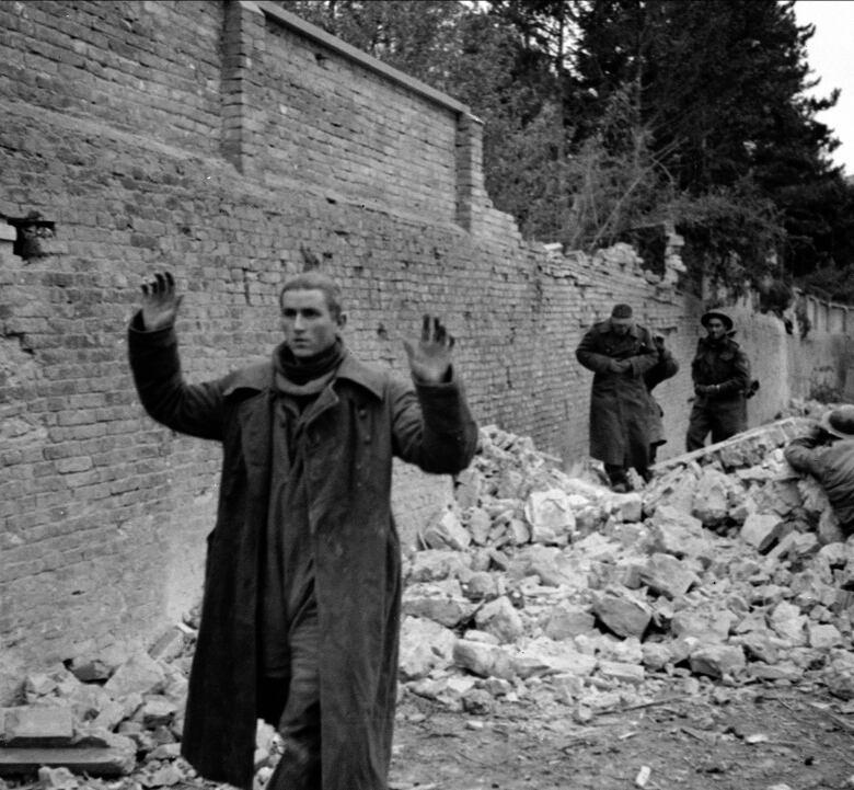 A black and white photos shows German soldiers surrendering to Canadian soldiers during the Second World War in Ortona, Italy.