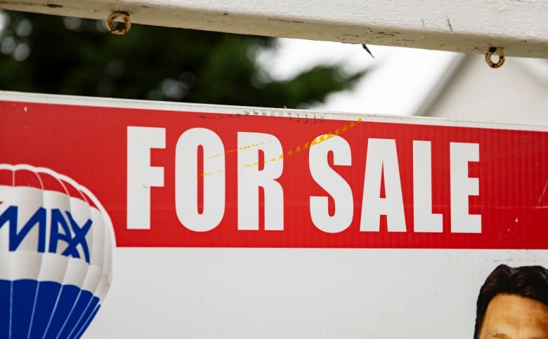 Closeup image of a real estate sign saying 'For Sale' 