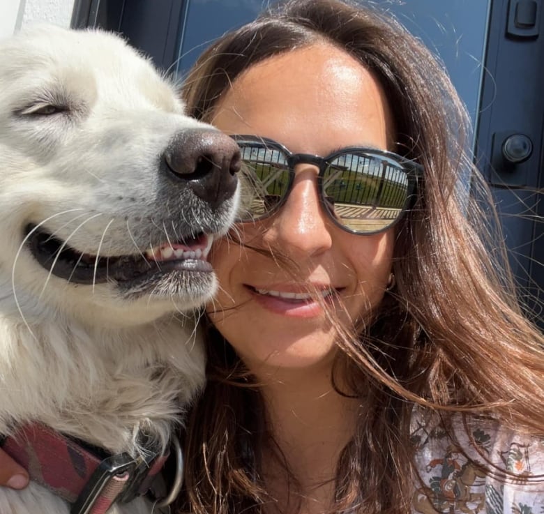 A woman poses for a photo with her dog.