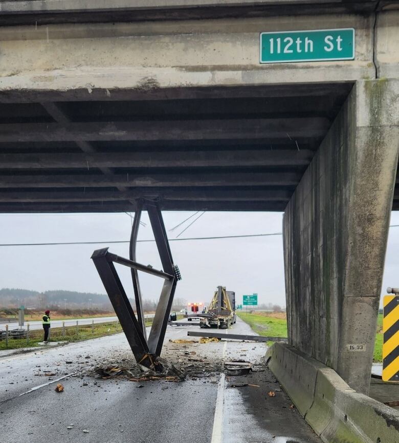 Debris and cargo lie under an overpass after a semi-truck collided with the bridge