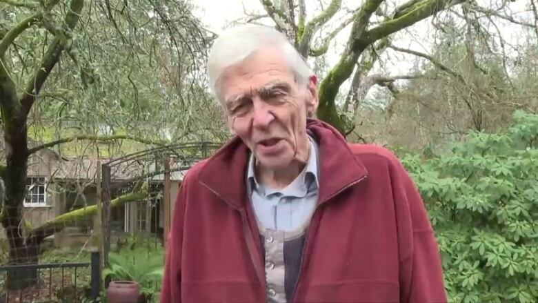 An older man on a treed property.