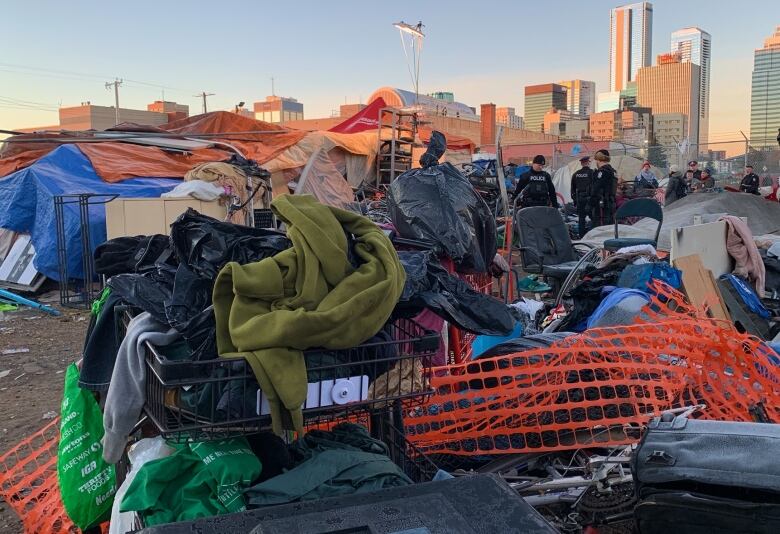 Police standing in the encampment with the city in the background.