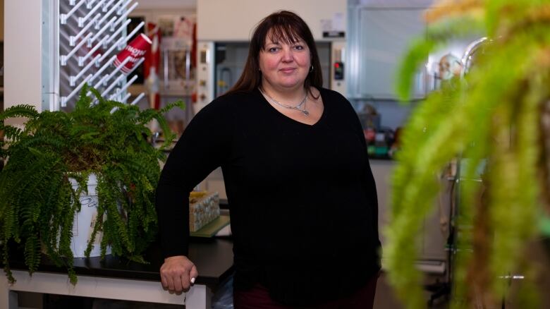 A woman stands in science lab.