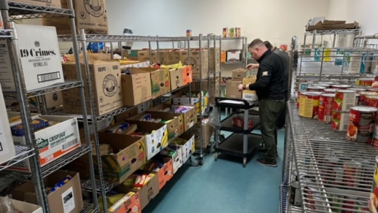 People are seen stocking shelves at a food bank.