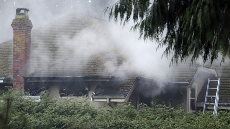 Smoke rises from a single-family home.