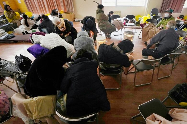 People in chairs lean as they sleep standing up.