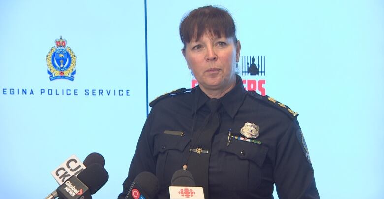 A person wearing a police uniform stands behind a podium.