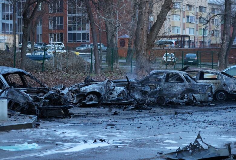 Burned-out cars and debris in a parking lot 