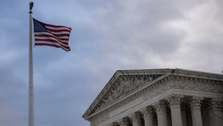 An exterior view of the U.S. Supreme Court in Washington, D.C., with an American flag on a flagpole