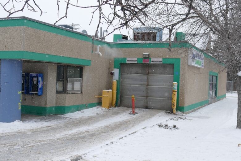 A pylon sits in the way of the entrance to a car wash, 