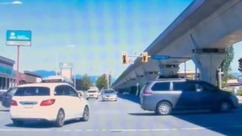 A car drives through a rad light at an intersection in what Richmond RCMP claim is an attempt to evade police following an illegal ride-hailing operation.