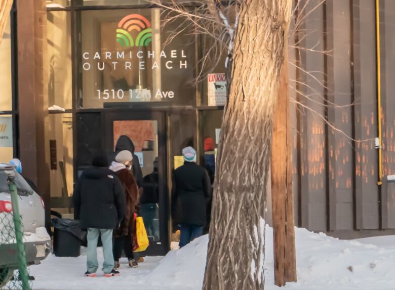 people in winter clothes lined up outside a building