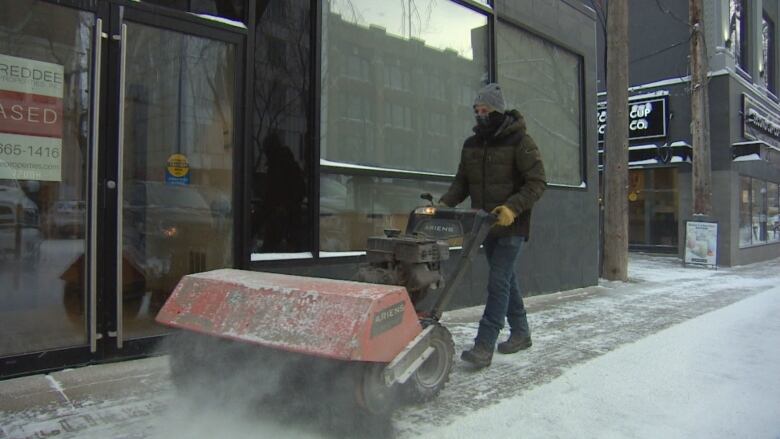 A man clearing a Saskatoon sidewalk on Thursday