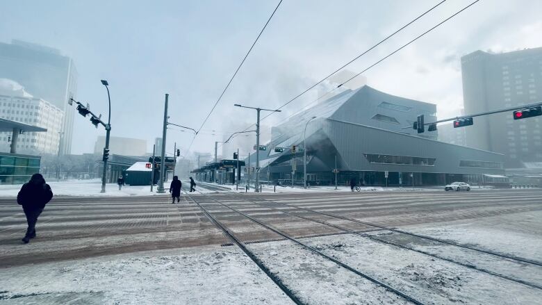 An icy street. A few people can be seen walking 